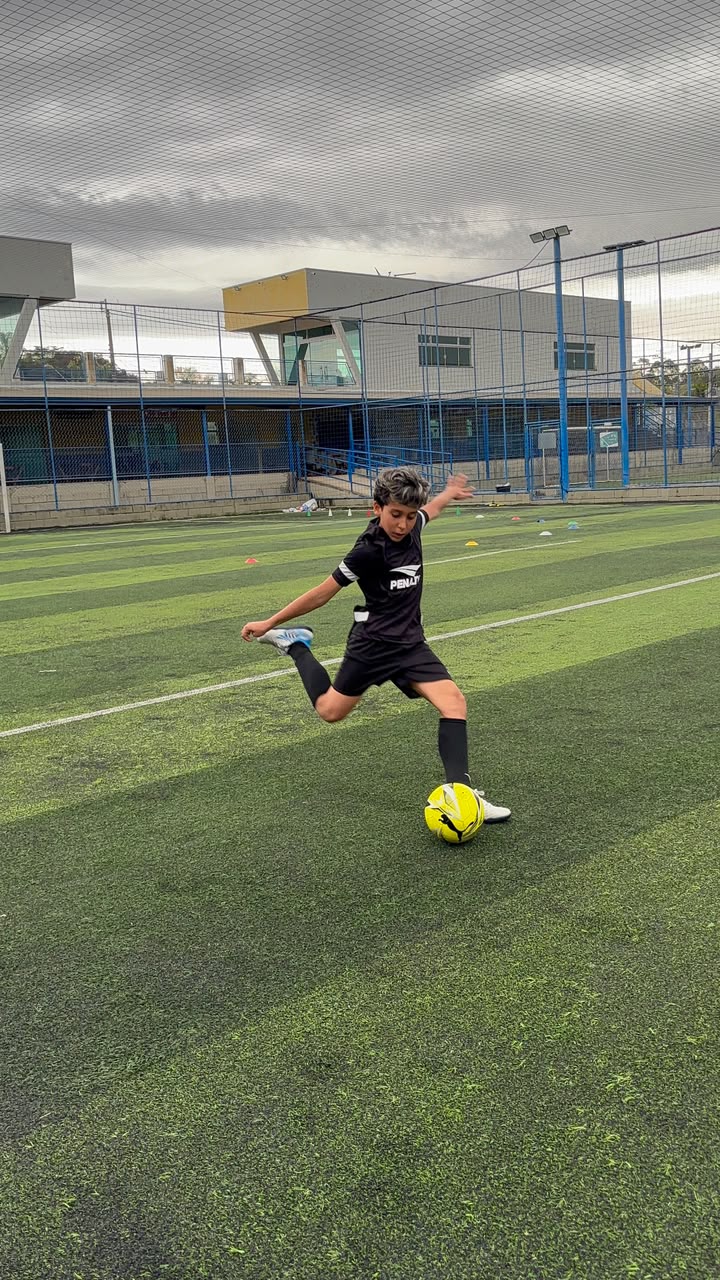 Atleta com o pé sobre a bola durante o treino